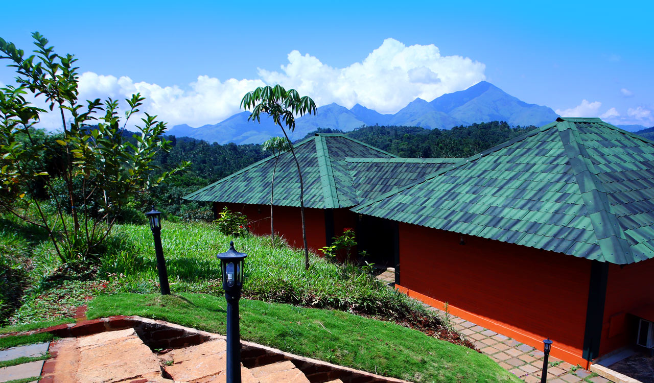 Heritage cottages of Petals Resort against the Western Ghats